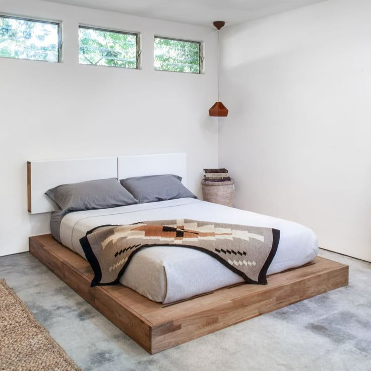 a bed sitting on top of a wooden platform in a bedroom