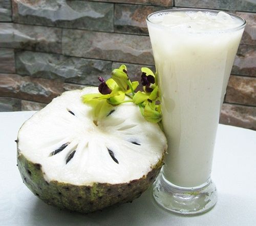 a kiwi fruit next to a glass of milk