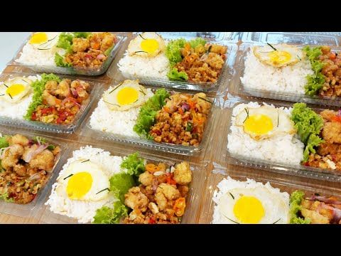 there are many different types of food in the trays on the table, including rice and fried eggs