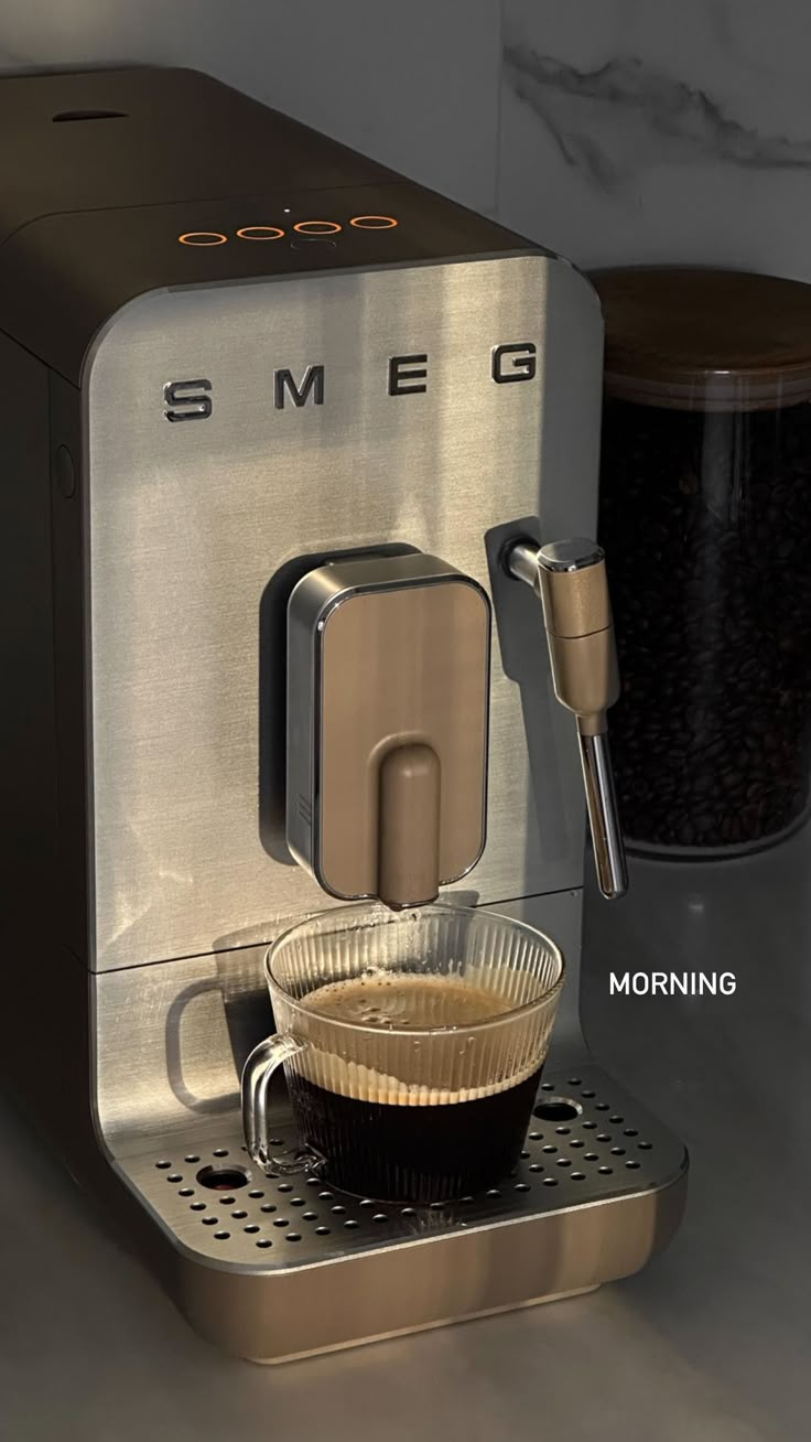 an espresso machine sitting on top of a counter next to a coffee cup