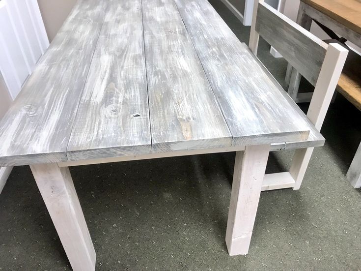 a wooden table sitting next to two chairs in a room with other furniture on the floor