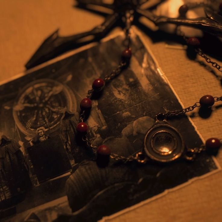 an old photo and rosary on a table