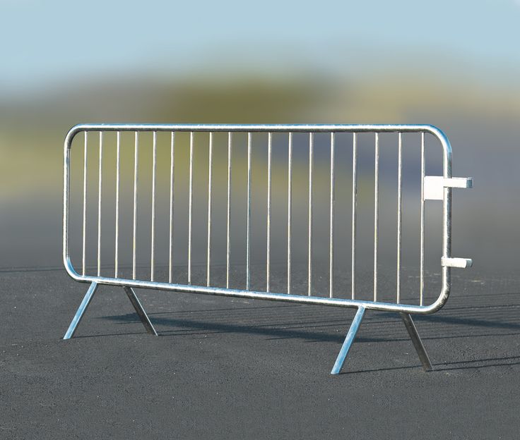 a white metal barricade sitting on top of a black floor next to a green field