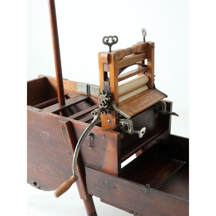 an old fashioned sewing machine sitting on top of a wooden box with wheels and handles