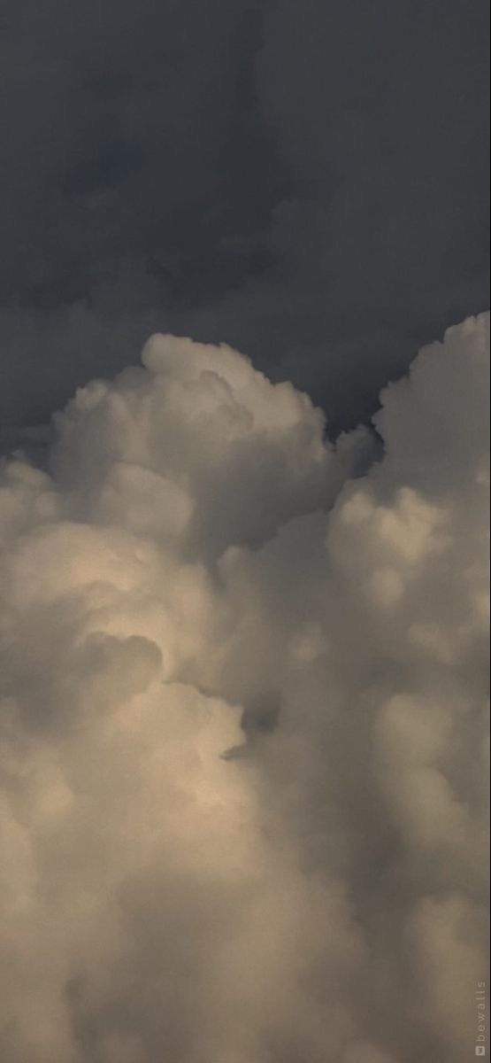 an airplane is flying high in the cloudy sky