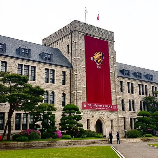 a large building with a flag on the front and two men standing in front of it