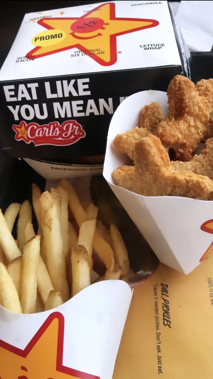 chicken nuggies and fries are sitting on the table next to some boxes of food