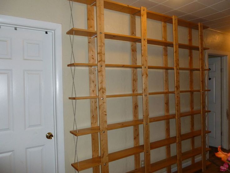 an empty room with wooden shelves on the wall and a white door in the background