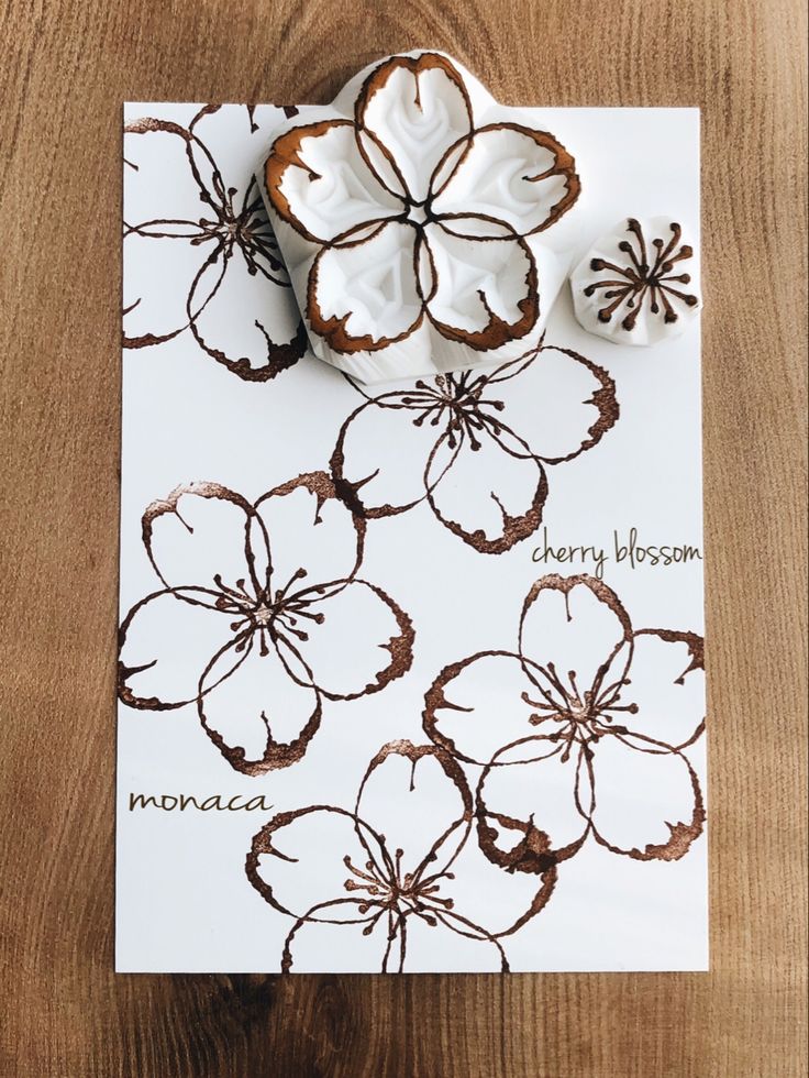 a piece of paper with flowers on it and two cookie cutters next to it