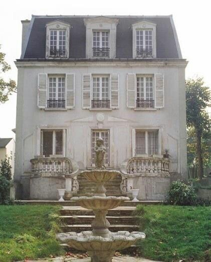 an old house with a fountain in front of it