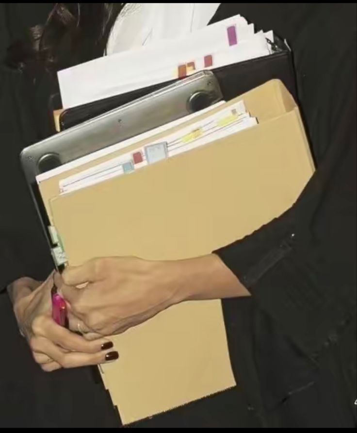 a woman holding a folder and pen in her hand