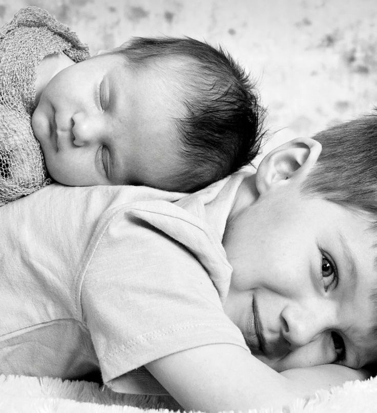 two young children laying next to each other on a bed