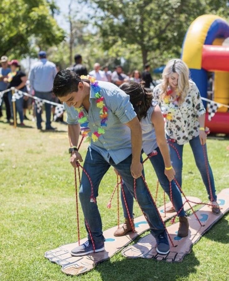 two young people are playing with ropes in the park while others watch from behind them