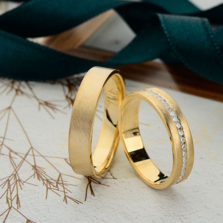 two wedding rings sitting on top of a table