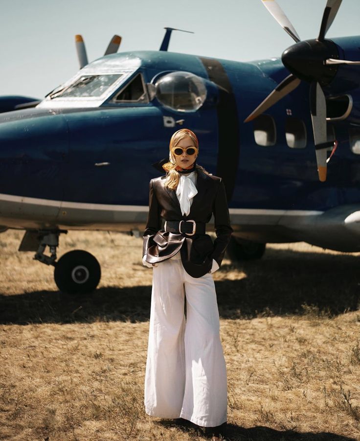 a woman standing in front of an airplane