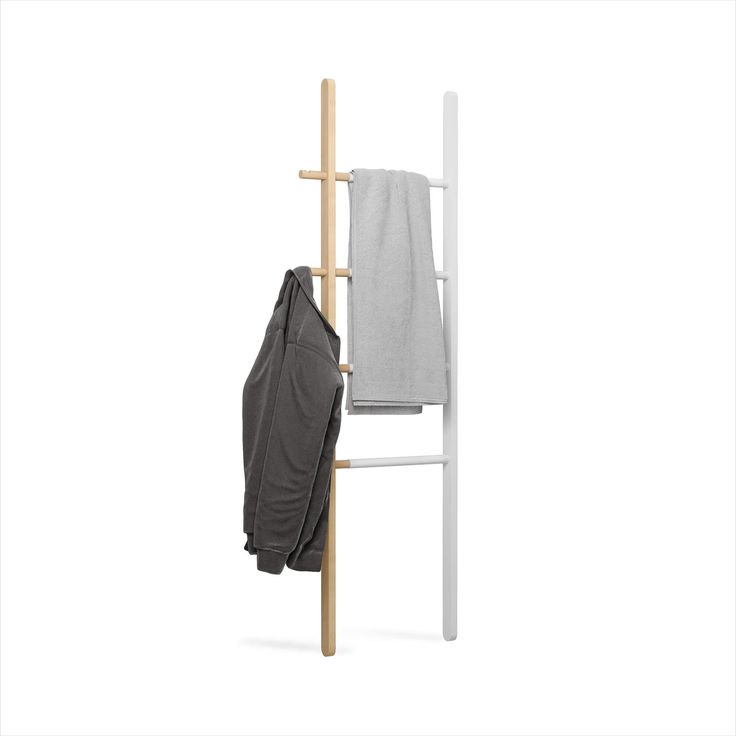 a coat rack with two coats hanging from it's sides and a towel on the back