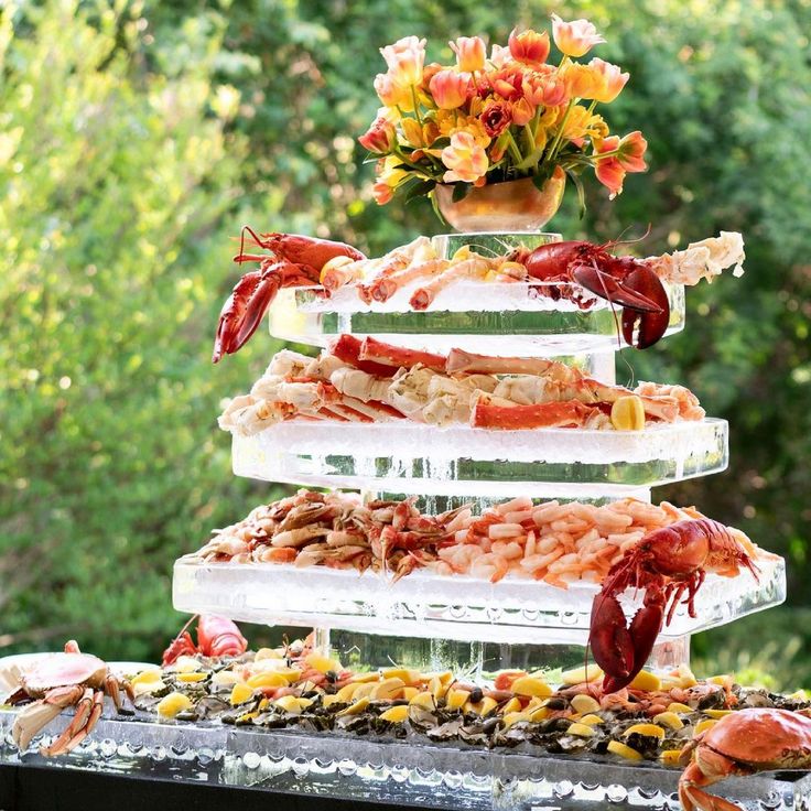 an assortment of seafood is displayed on top of a buffet table in front of trees