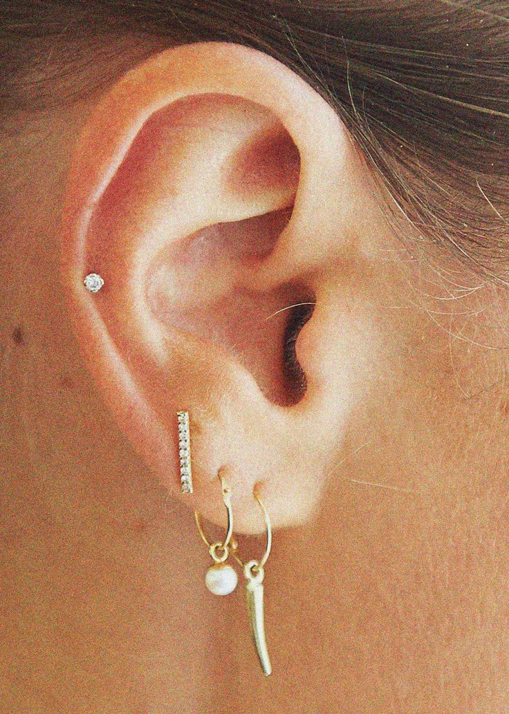 a close up of a person's ear with a pair of earrings on it