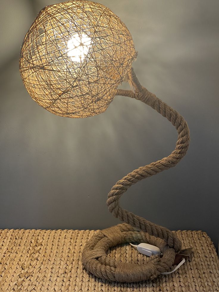 a lamp that is sitting on top of a table next to a roped light