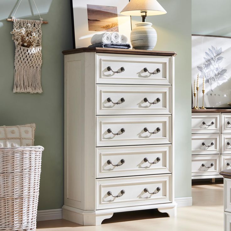 a white dresser sitting in a bedroom next to a lamp