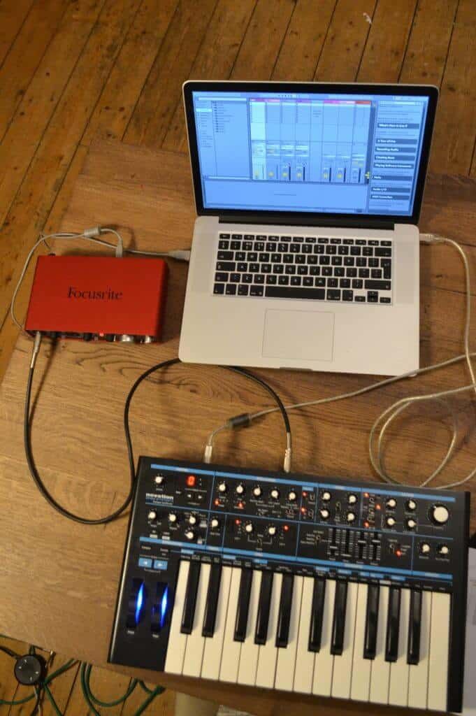 an open laptop computer sitting on top of a wooden table next to a keyboard and mouse