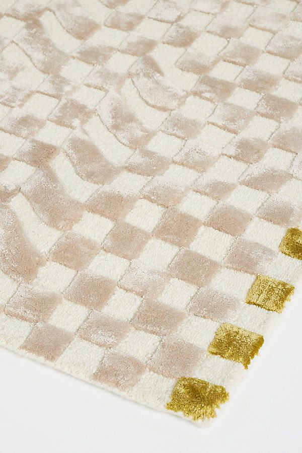 a white rug with gold squares on it