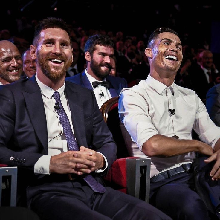 three men in suits and ties are smiling at the camera while sitting next to each other