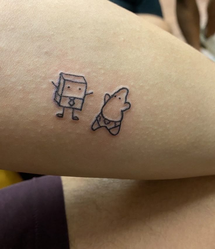 a person with a small tattoo on their arm that has an image of a dog and a cat