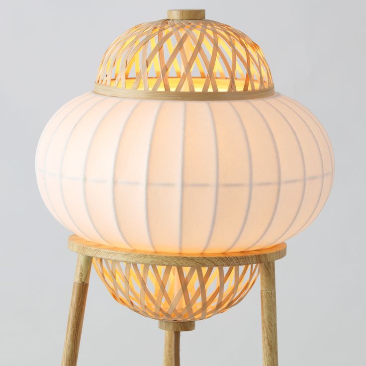 a white lamp sitting on top of a wooden stand