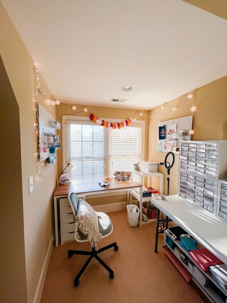 a room with a desk, chair, and shelves in the corner that are decorated with christmas lights