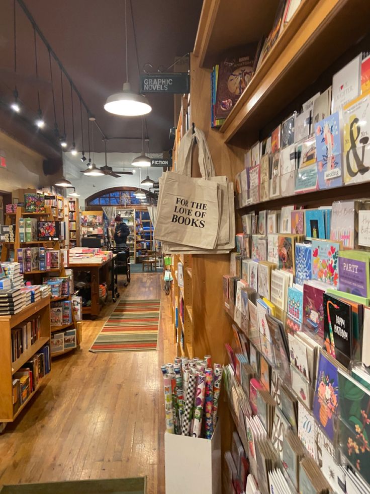 the inside of a book store with books on shelves and bags hanging from the ceiling