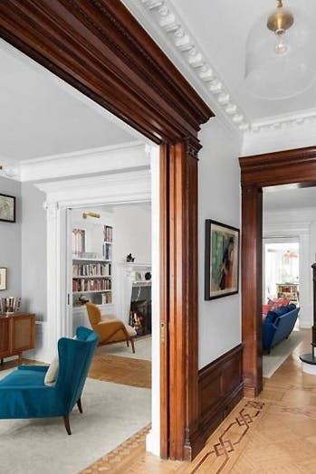 a blue chair sitting in the middle of a living room next to a stair case