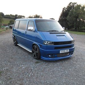 a blue van parked on top of a gravel road