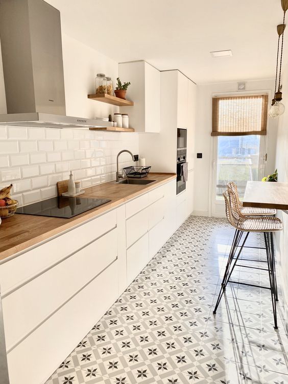 a kitchen with tiled floors and white cabinets