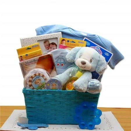 a teddy bear sitting in a blue basket filled with baby items on top of a wooden table