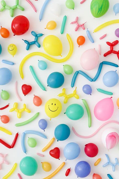 many different colored balloons and decorations on a white surface