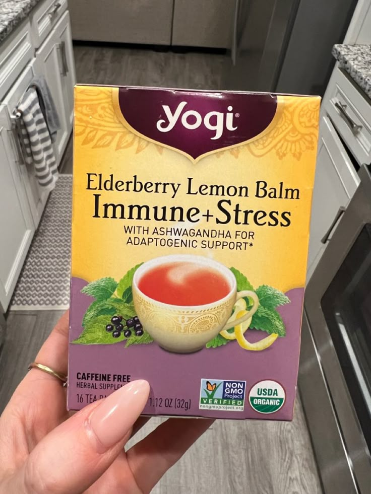 a box of yogi elderberry lemon balm in someone's hand next to an oven