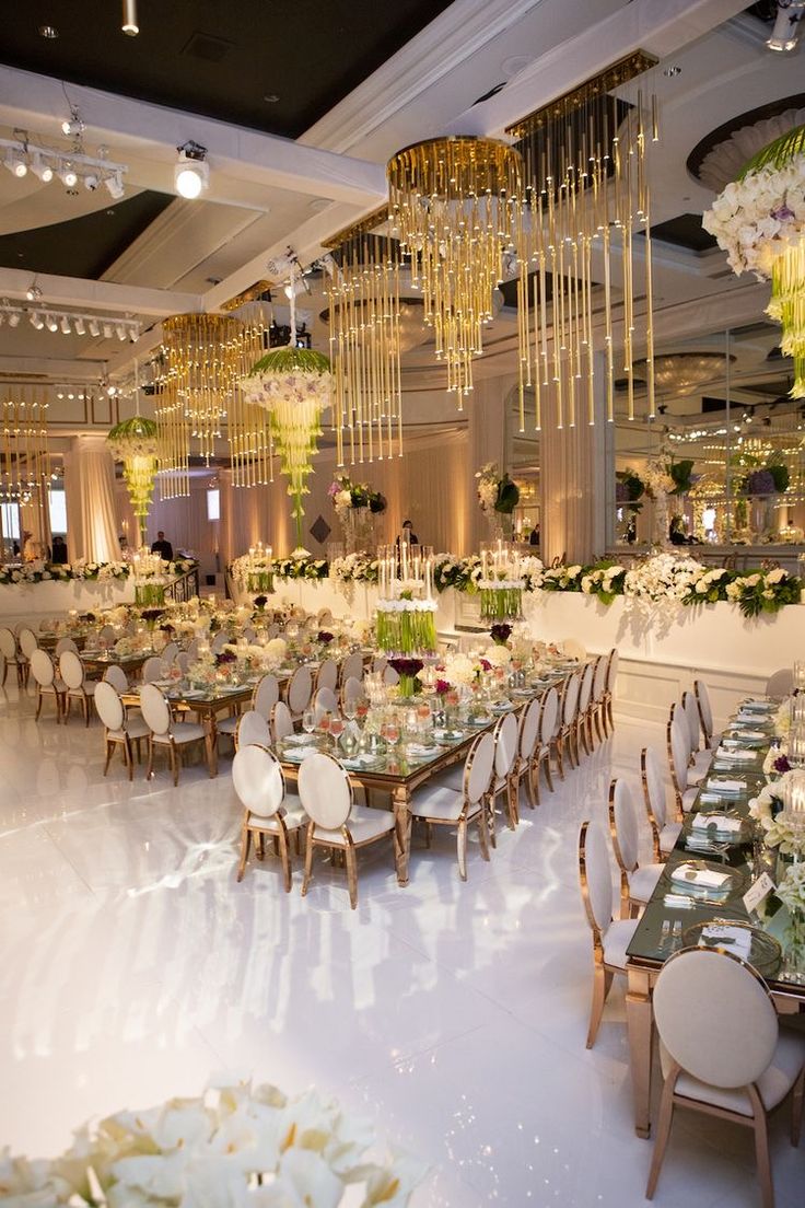 a banquet hall with tables, chairs and chandeliers