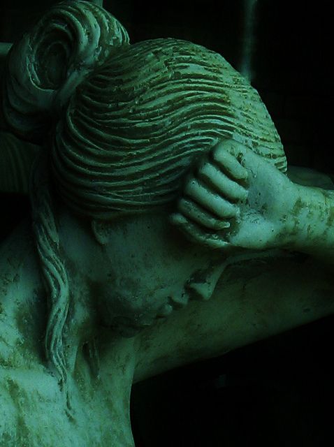 a close up of a statue of a woman with her hand on her head