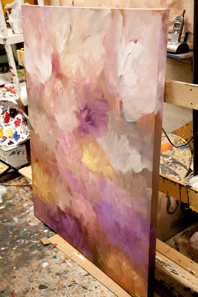 an abstract painting is being worked on in a studio