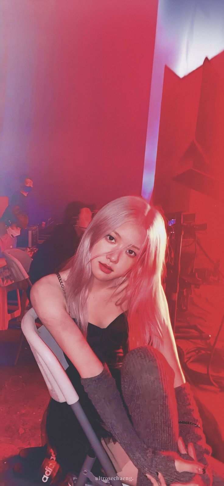 a woman sitting on top of a chair next to a red and blue wall in a room