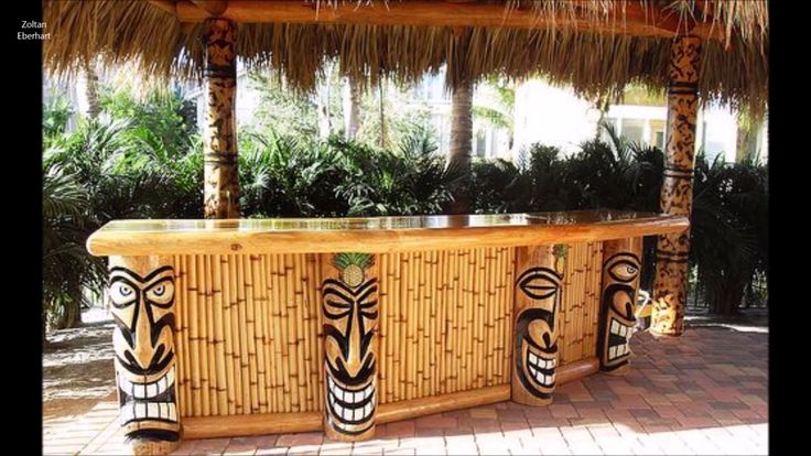 an outdoor bar with tiki faces painted on it