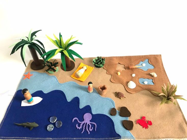 an ocean scene made out of felt with toys and plants on the ground next to it