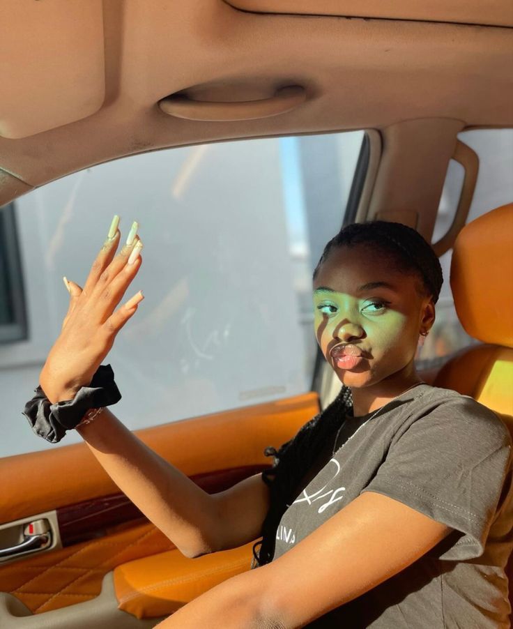 a woman with green face paint sitting in a car