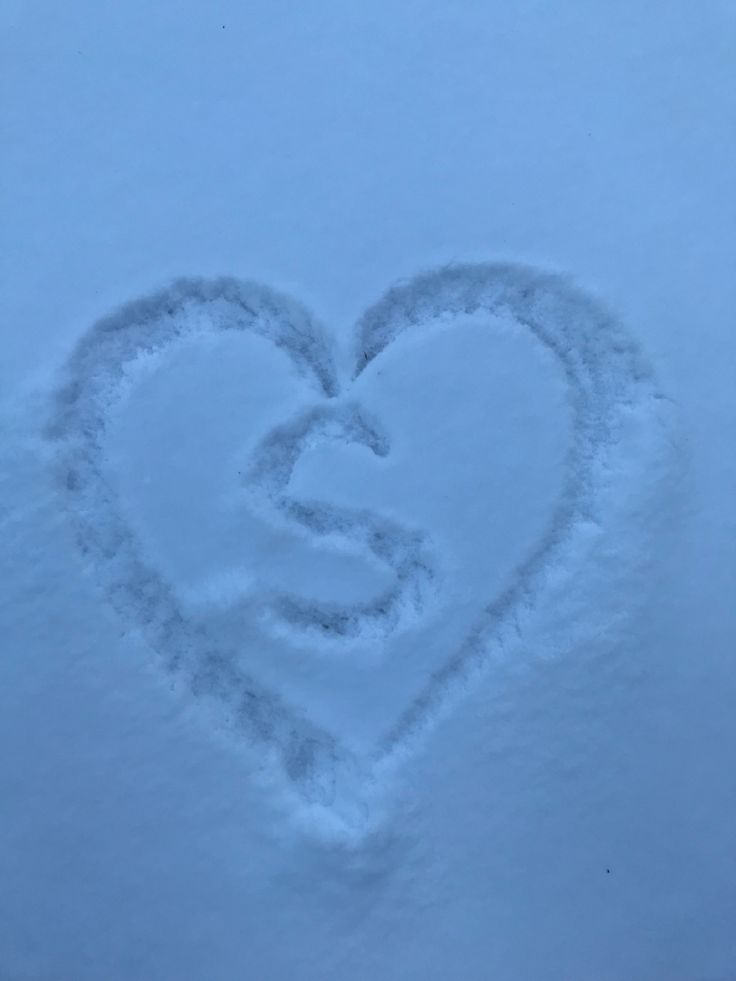 a heart shaped in the snow on a sunny day