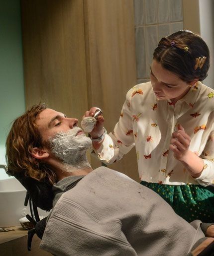 a man shaving his daughter's face in the bathroom