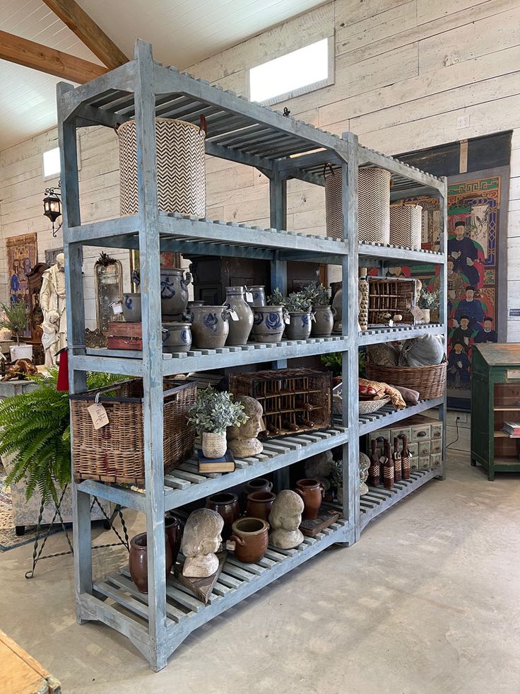 several shelves filled with pots and baskets in a room