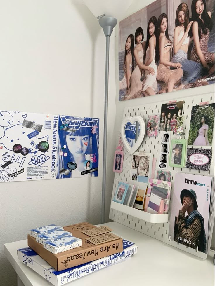 a desk with several books and pictures on the wall