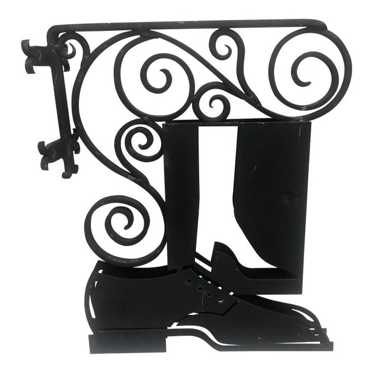 a pair of black shoes is attached to a wrought iron shelf