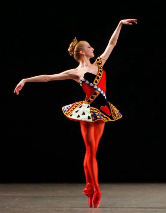 a ballerina in red and yellow is doing a trick